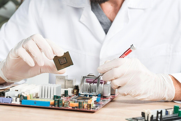 Technician repairing circuit board with microchip tool Technician repairing circuit board with microchip tool